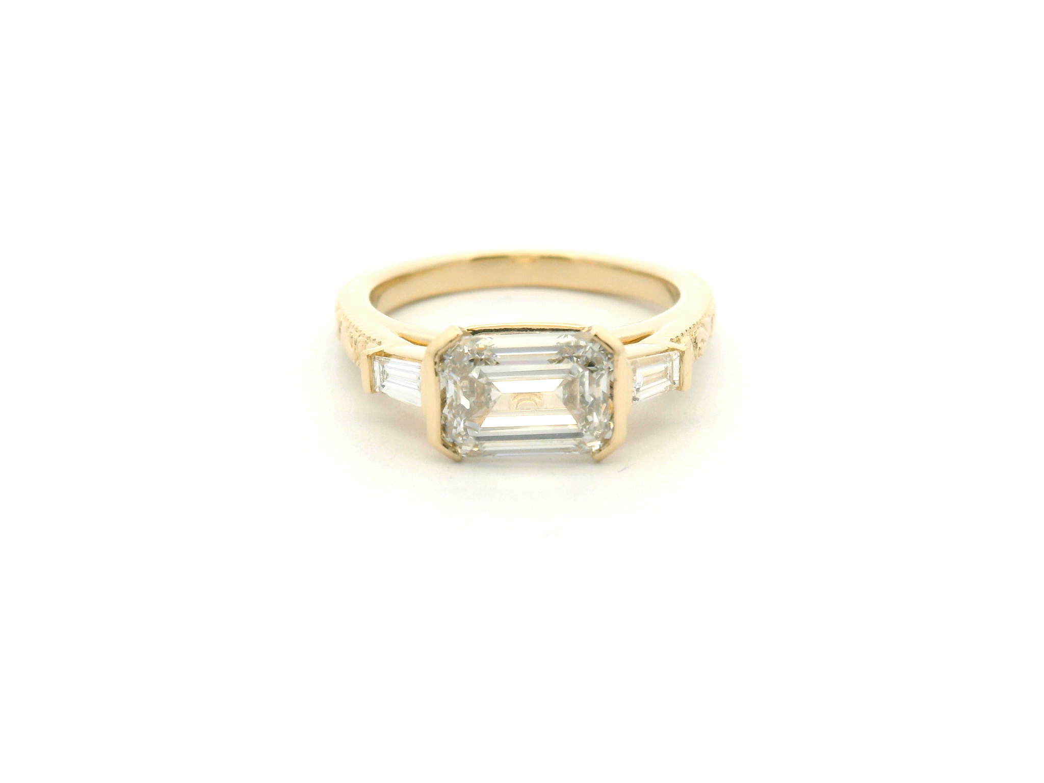 East-West Emerald Cut Diamond Ring with Half Bezel, Tapered Baguettes & Engraved Shank