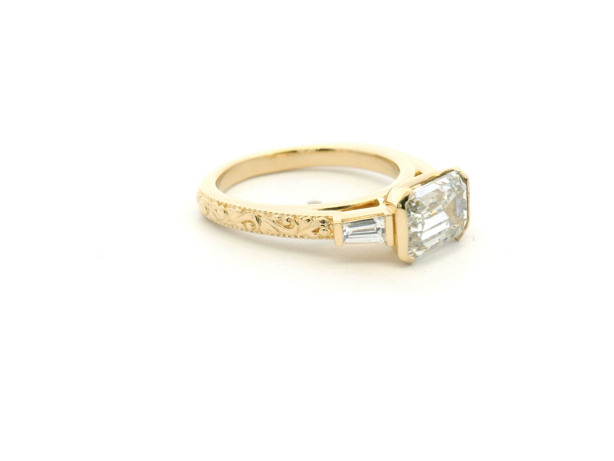 East-West Emerald Cut Diamond Ring with Half Bezel, Tapered Baguettes & Engraved Shank
