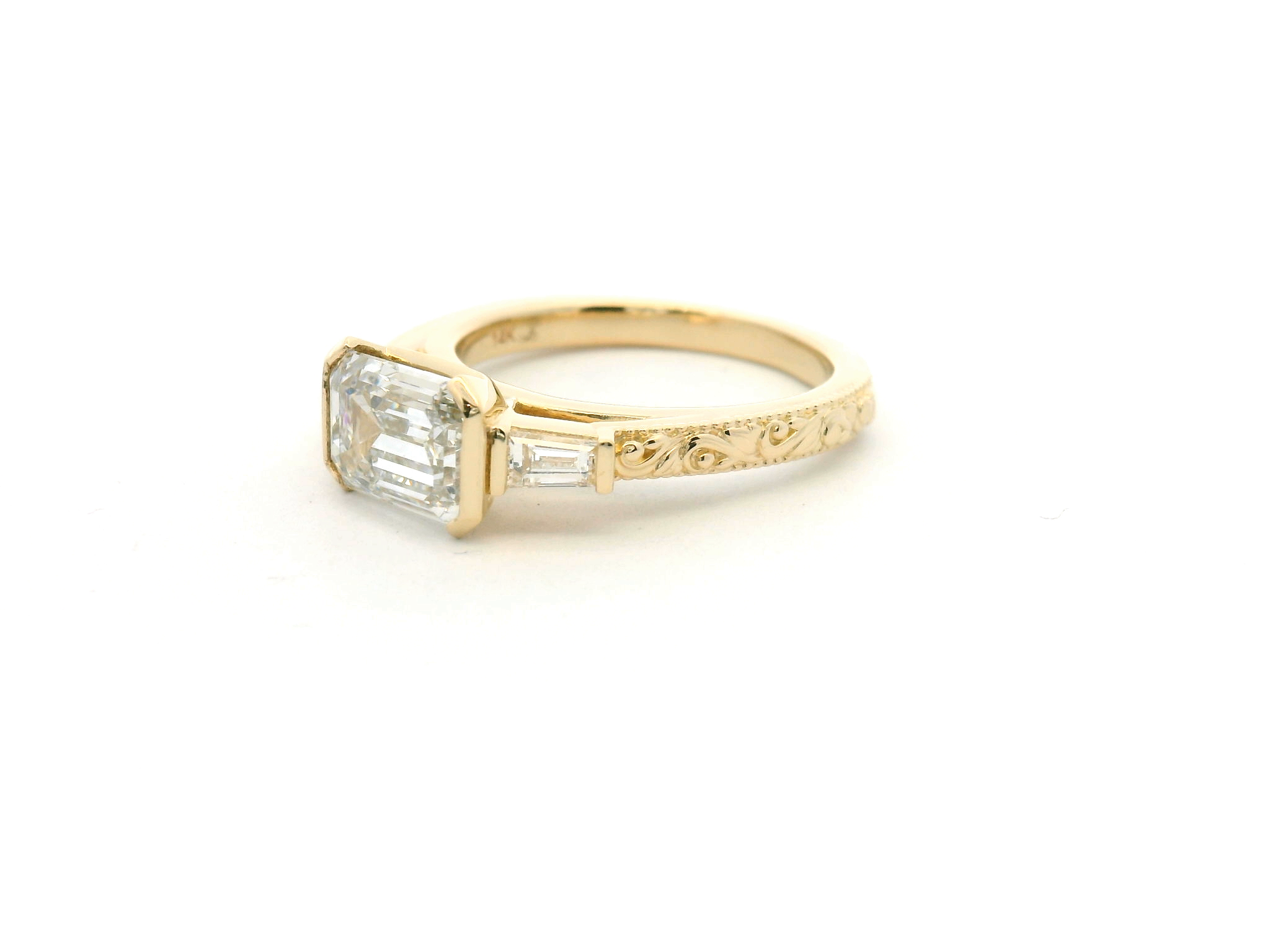 East-West Emerald Cut Diamond Ring with Half Bezel, Tapered Baguettes & Engraved Shank